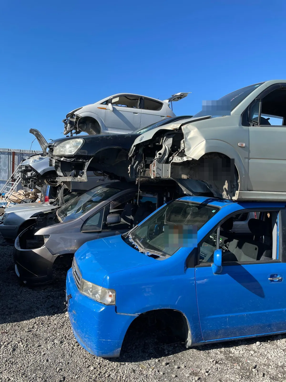 部品を外し終えた車体を多段に積み上げた国内の解体ヤード